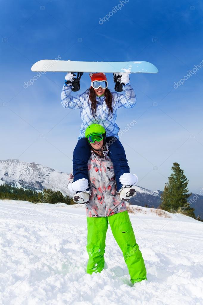 Snowboarder with girl  on his shoulders