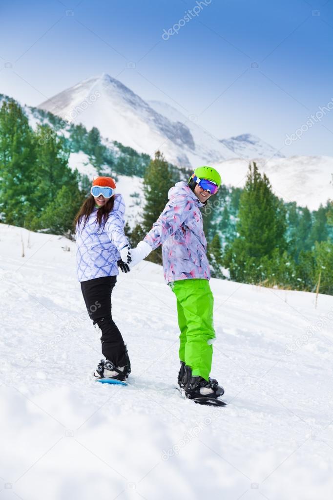 Couple standing on snowboards