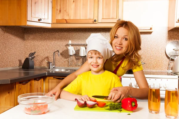 Boy   cuts vegetables with mother — Stock Photo, Image