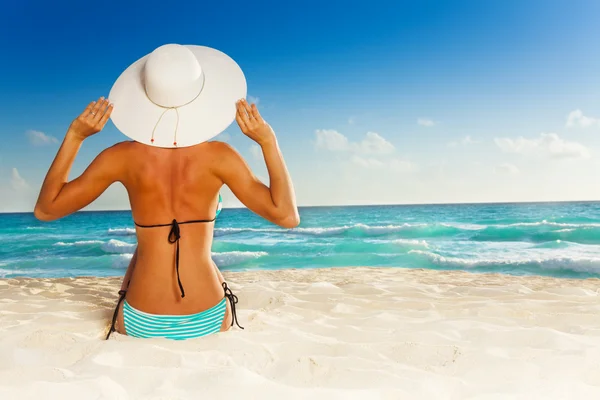 Meisje zitten op het strand — Stockfoto