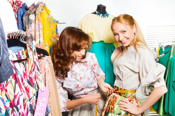 Women measuring size of  skirt — Stock Photo, Image