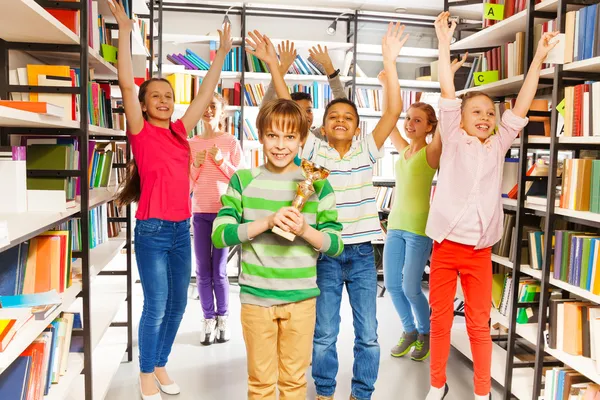 Junge hält Pokal in Bibliothek — Stockfoto