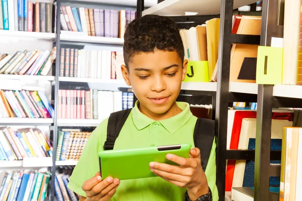 Junge mit Tablet in Bibliothek — Stockfoto