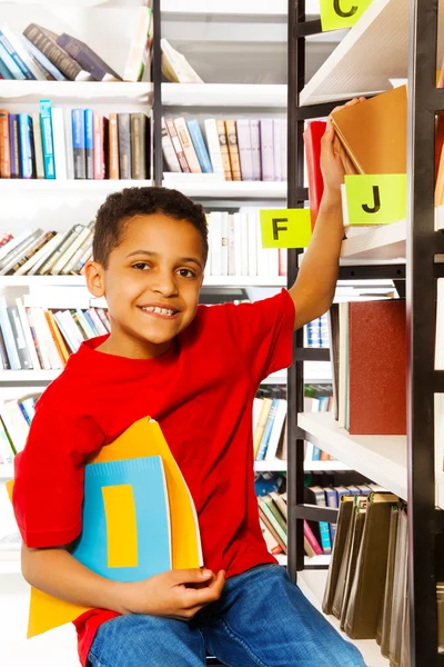 Pojken håller böcker — Stockfoto