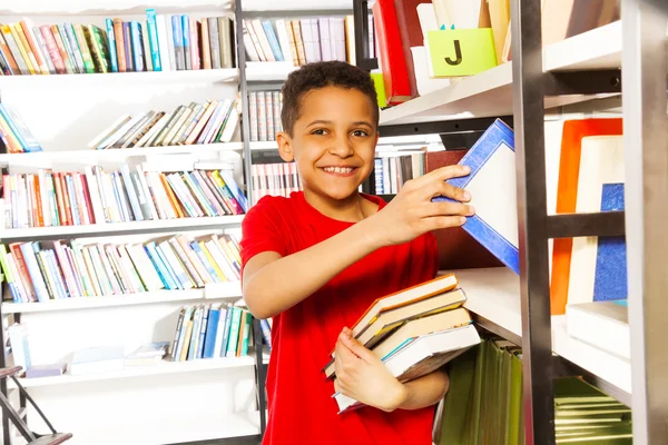 Мальчик держит много книг — стоковое фото