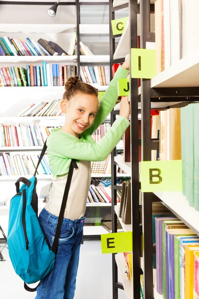 Schoolgirl  searching books — Stock Photo, Image
