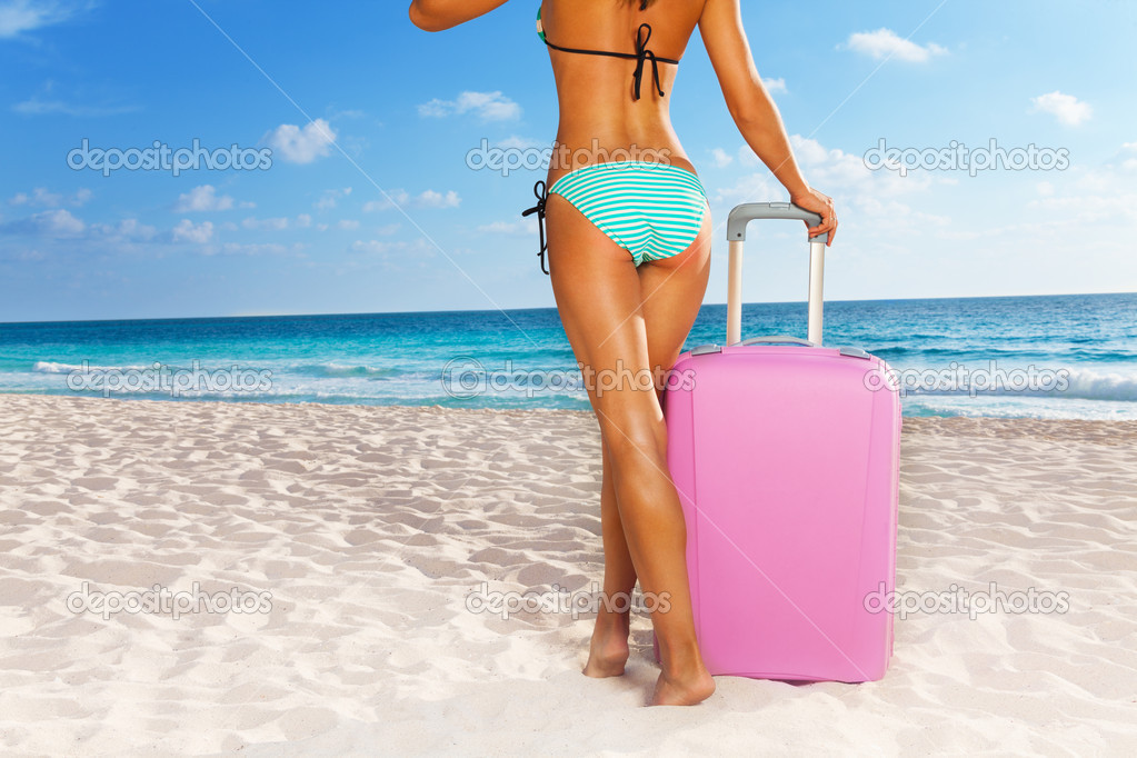 Woman with suitcase on beach