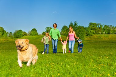 Aile ile çalışan köpek parkta yürüyor.