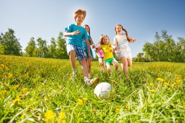 yeşil alan futbol oynayan mutlu çocuklar