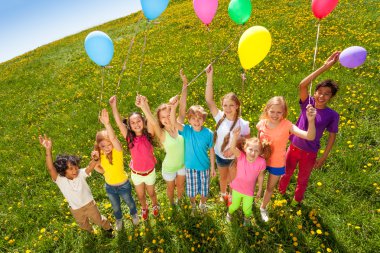 üstten duran çocuklara balon göster