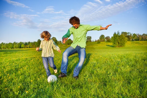 Father and boy playing football together in park — Stock Photo, Image
