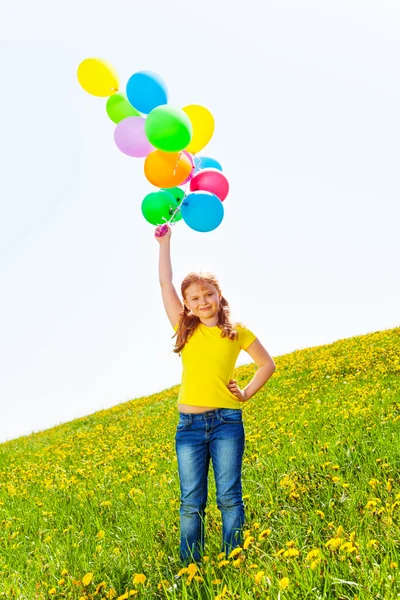 Happy girl with many flying balloons in the air — Stock Photo, Image