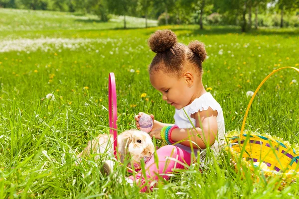 Small girl with Eastern egg and rabbit in park — Stock Photo, Image