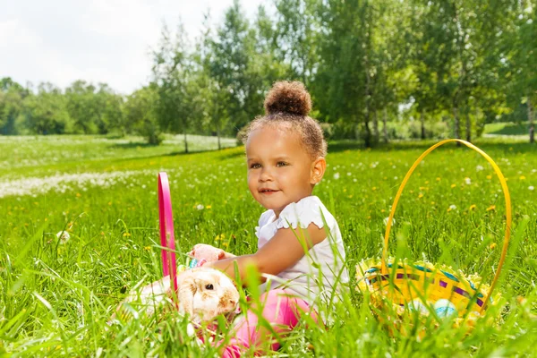 Gekrulde schattig meisje met konijn in groen park — Stockfoto