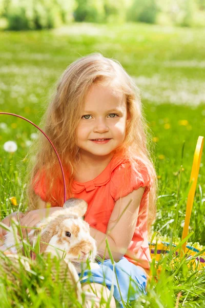 Маленькая девочка с кроликом в корзине — стоковое фото