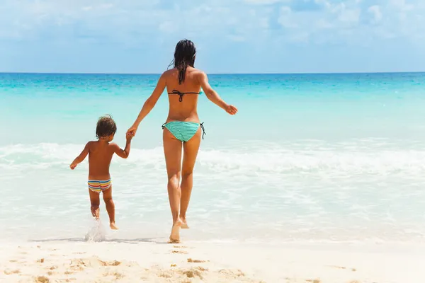 Kind en vrouw hand in hand op zee achtergrond — Stockfoto