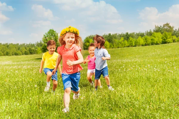 Niños corriendo felices en el campo verde durante el verano — Foto de Stock