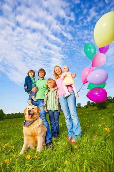 Rodzice, dzieci i pies stoisko z balonów w parku — Zdjęcie stockowe