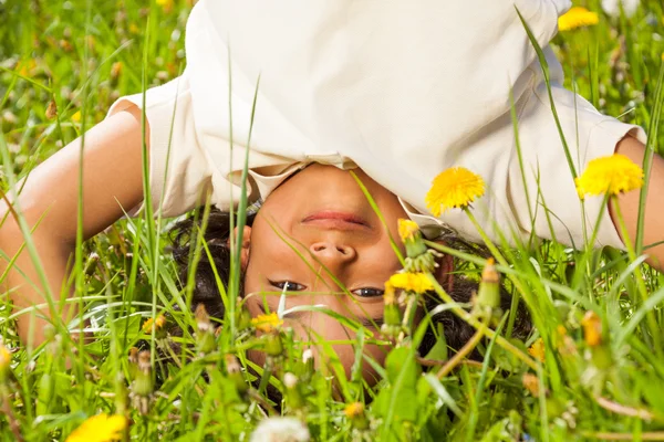 Cute curly boy stands upside down in field — Stock Photo, Image
