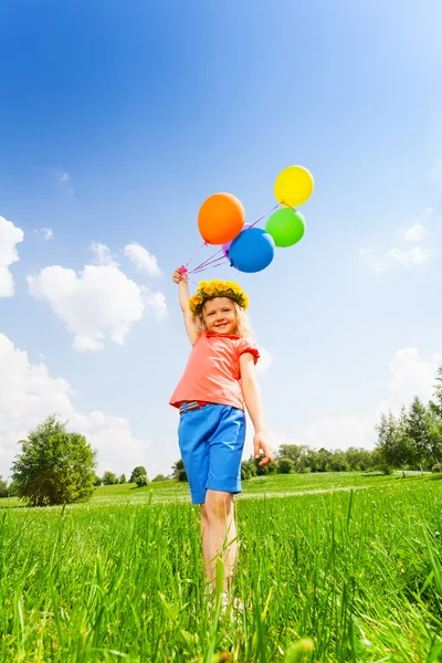 Kleines Mädchen mit bunten Luftballons im Kreis — Stockfoto