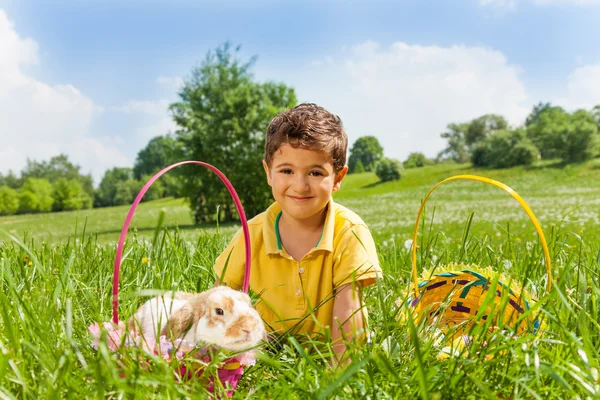 Pojke med kanin och två korgar i parken — Stockfoto
