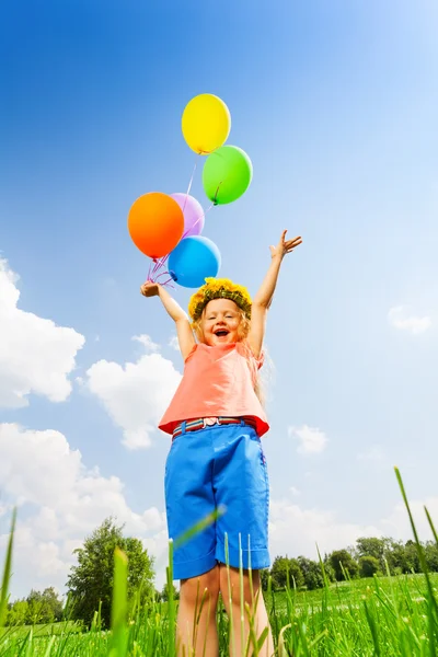 Glückliches Mädchen mit Luftballons im Blumenkreis — Stockfoto