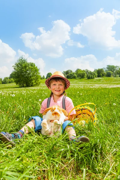 肯定的な男の子の帽子をかぶって、ウサギを抱き締める — ストック写真