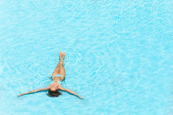 Ung kvinna bada i kristallklart poolen — Stockfoto