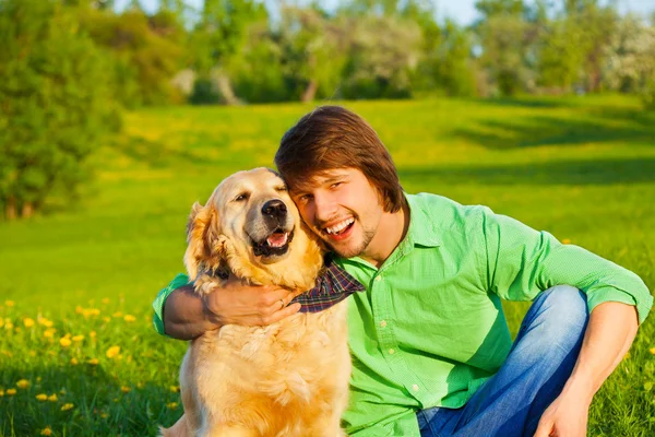 Happy dog and man in the park together — Stock Photo, Image