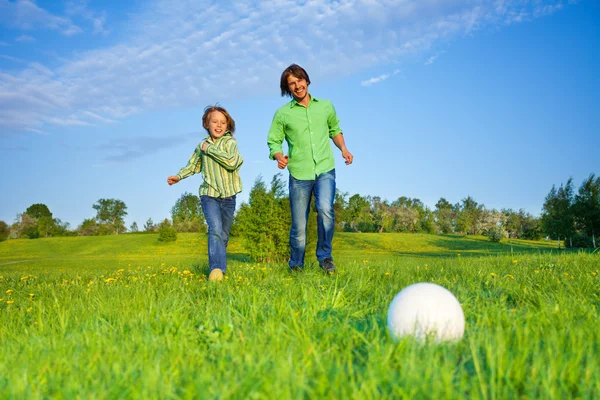 Far och barn spelar fotboll i parken — Stockfoto