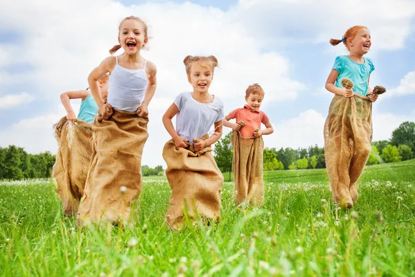 Kids jump in sacks — Stock Photo, Image