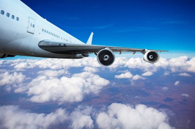 Jet motorları ve kanat ekinleri bulutların arasında uçuyor.
