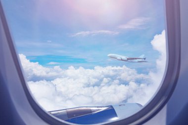 Başka bir büyük ticari jet uçağının penceresinden yüksek irtifada bulutların üzerinde uçarken görüntüsü