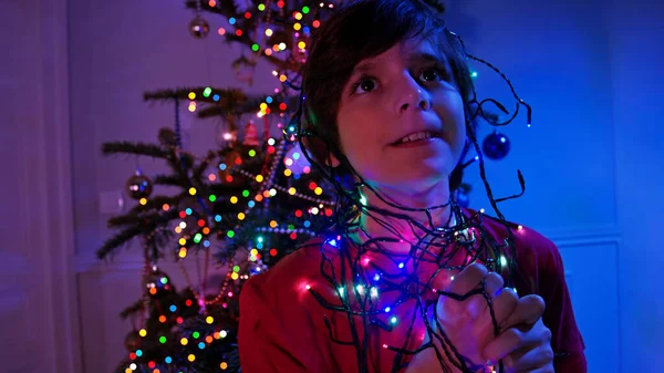 一个面带笑容 面带微笑的男孩在圣诞树旁的画像 — 图库照片