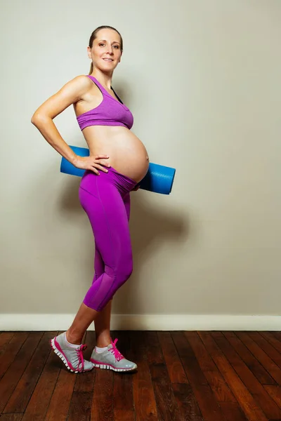 妊娠中の女性のスポーツの概念 家庭でフィットネス年齢とスポーツ服を持つ将来のお母さん — ストック写真