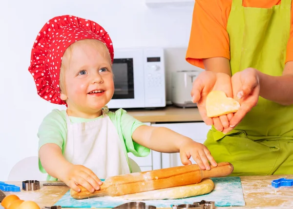孩子们戴着厨师的帽子 快乐地笑着带着柱塞的幼儿面团 兄弟们表现出心形饼干 — 图库照片