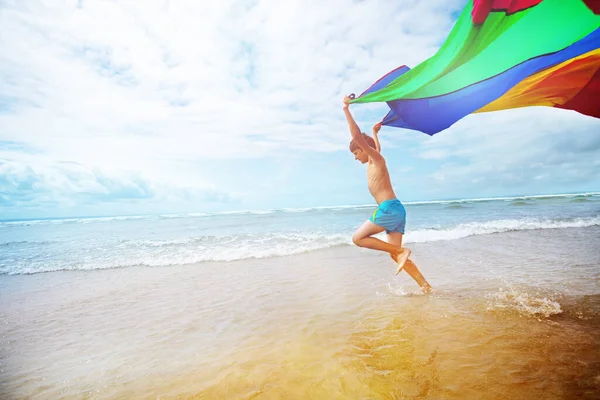 Jongen Uitgevoerd Met Een Kleurrijke Parachute Stof Zee Het Strand — Stockfoto