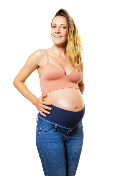 孕妇在大肚子里打洞 站在白色的焦点上 腰部看着摄像机 — 图库照片