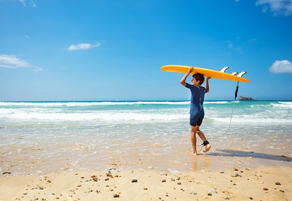 Glad Liten Pojke Baddräkt Havsvågor Med Orange Surfbräda Handen Stranden — Stockfoto