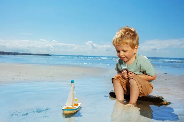 Mały Nawigator Bawić Się Żaglowcem Małym Wiosła Plaży Pobliżu Morza — Zdjęcie stockowe