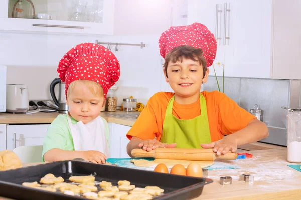 Çocuklar Aşçı Şapkası Takıyor Gülümsüyor Mutfak Masasında Pompayla Hamuru Sarıyorlar — Stok fotoğraf