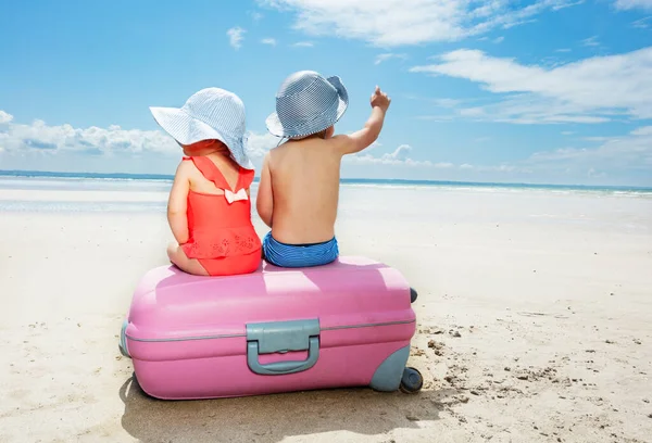 Dwa Słodkie Dzieci Siedzieć Walizce Chłopiec Punkt Palec Dziewczyna Plaży — Zdjęcie stockowe