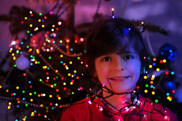 Fechar Retrato Menino Com Luzes Iluminadas Guirlanda Sobre Rosto Perto — Fotografia de Stock