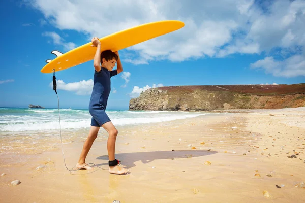 Счастливый Мальчик Гидрокостюме Ходить Доской Серфинга Над Головой Руках Вернуться — стоковое фото