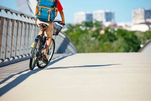 男の子の後ろからの眺めは 車輪の上に近いベークレーンで自転車に乗るバックパックを着用してください — ストック写真