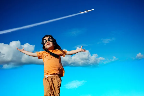 小さな幼児男の子で航空機の帽子とグーグルで幸せ持ち上げ手以上商業ジェット飛行機で空 ストック画像