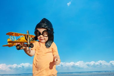 Havacılık şapkalı çocuk ve pilot Google oyuncak uçakla oynuyor.