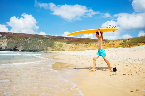 Szczęśliwy Chłopczyk Spodenkach Biegnie Pomarańczową Deską Surfingową Dłoni Fal Morskich — Zdjęcie stockowe