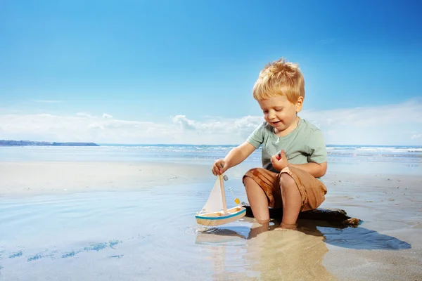 Małe Dziecko Siedzieć Zabawką Statku Kałuży Plaży Morze Tle — Zdjęcie stockowe
