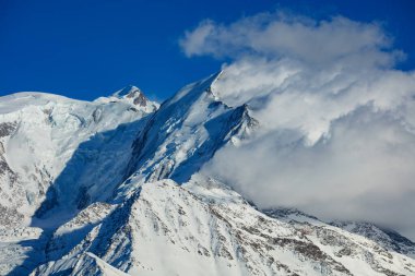 Panorama of mountain range of Mont Blanc massive mountains with clouds on one side of the peak